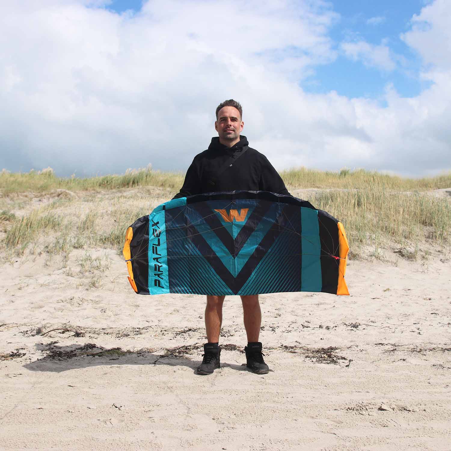 Lenkmatte schwarz, blau, orange mit Mann als Größenvergleich am Strand